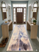 2.8' x 8' runner beige & blue abstract watercolor modern area rug styled in an entryway with light wood furniture and soft blue walls.