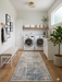 2.8' x 8' runner ivory & blue distressed linear modern area rug placed in a clean laundry room with white cabinetry and modern appliances.