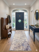 2.8' x 8' runner ivory gray & blue marble swirl abstract modern area rug styled in an entryway with a dark front door, console table, and minimal decor.