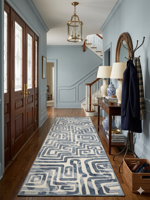 2.8' x 8' runner ivory & gray geometric maze modern area rug styled in an entryway with classic wood furniture and soft blue walls.