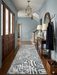 2.8' x 8' runner ivory & gray geometric maze modern area rug styled in an entryway with classic wood furniture and soft blue walls.