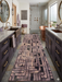 2.8' x 8' runner taupe & brown geometric maze modern area rug placed in a modern bathroom with dual vanities and a freestanding tub.