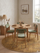 6' Round Gold & Brown Distressed Abstract Modern Washable Area Rug styled in a dining area with a round table, upholstered chairs, and soft natural light.