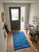 2' x 3' Rectangular Blue Multicolor Border Modern Washable Area Rug styled in a welcoming entryway with a gray front door and wood console table.