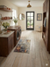2' x 3' Rectangular Gray Gold Abstract Modern Washable Area Rug styled in a laundry room with built-in dark wood cabinetry, front-loading washer and dryer, and a glass-paneled back door.