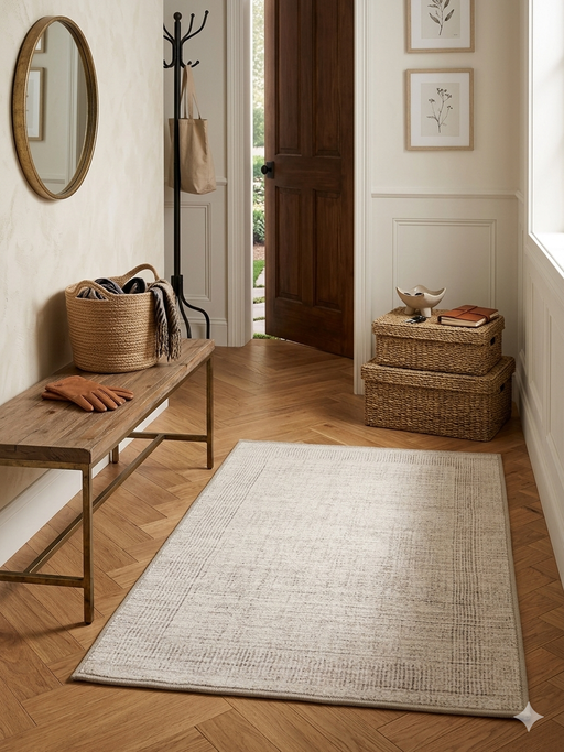 2' x 3' Rectangular Ivory & Beige Distressed Abstract Modern Washable Area Rug styled in a welcoming entryway beside a wooden bench.