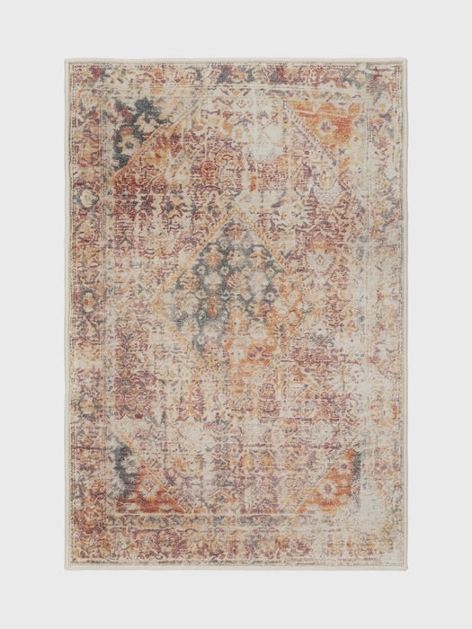 6' x 9' Rectangular Rust Pink Southwestern Tribal Geometric Area Rug featured in a living room with a sofa, coffee table, and brick fireplace backdrop.