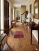 2' x 3' Rectangular Red & Black Geometric Medallion Traditional Washable Area Rug placed in an entryway hallway with a console table, mirror, and warm wood flooring.