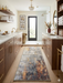 2' x 4' Rectangular Gray Gold Abstract Modern Washable Area Rug placed in a luxurious bathroom with dual vanities, open shelving, and a walk-in shower.