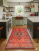 2' x 4' Runner Coral Red Tribal Medallion Traditional Washable Area Rug placed in a kitchen between cabinets with warm wood flooring and a farmhouse sink.