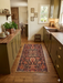 2' x 4' Runner Rust & Black Tribal Geometric Traditional Area Rug styled in a kitchen with wood cabinetry, open shelving, and natural light.