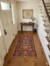 2' x 4' Runner Rust & Black Tribal Geometric Traditional Area Rug styled in an entryway with a wooden console table, staircase, and warm lighting.