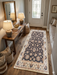 2' x 5' Runner Charcoal & Ivory Floral Traditional Washable Area Rug placed in a welcoming entryway beside a wooden console table.