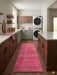 2' x 5' Runner Pink Distressed Modern Contemporary Area Rug placed in a laundry room walkway between cabinets.