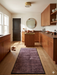 2' x 5' rectangular brown & rust geometric minimalist modern area rug placed in a kitchen with warm wood cabinetry and natural light.