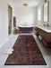 2' x 5' rectangular brown & rust geometric minimalist modern area rug styled in a bathroom with a freestanding tub and double vanity.