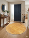 3' Round Yellow Gold Solid Minimalist Modern Area Rug placed in a bright entryway with wooden console table and décor accents.