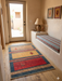 3' x 5' Rectangular Gold & Red Geometric Southwestern Area Rug placed in a warm entryway with adobe-inspired décor.