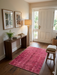3' x 5' Rectangular Rose Pink & Burgundy Distressed Vintage Area Rug styled in an entryway with wood flooring and minimal decor.