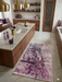3' x 5' rectangular gray & purple abstract watercolor modern area rug placed in a contemporary kitchen with warm wood cabinetry and brass pendant lighting.