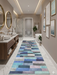 3' x 8' Runner Blue Mint Geometric Modern Washable Area Rug displayed in a spacious modern bathroom with marble floors, double vanities, and elegant gold accents.
