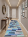 3' x 8' Runner Blue Mint Geometric Modern Washable Area Rug placed in a contemporary hallway with light wood flooring, framed abstract artwork, and a sleek console table.