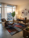 6' x 9' Rectangular Multicolor Red Blue & Charcoal Abstract Geometric Modern Area Rug styled in a home office with a wooden desk and lounge chair.