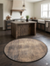 4' Round Beige & Brown Distressed Modern Abstract Area Rug placed in a rustic kitchen with wooden island and dark wood flooring.