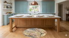 4' Round Beige Pink Abstract Floral Modern Washable Area Rug styled in a bright kitchen under a large wooden island.