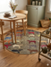 4' Round Gray Multi Color Animal Farm Rustic Novelty Area Rug styled in a dining nook with a round table and casual seating.