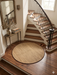 4 ft Round Natural Beige & Brown Woven Solid Modern Farmhouse Washable Area Rug styled in a staircase landing area.