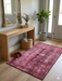 4' x 6' Rectangular Fuchsia Pink Distressed Abstract Modern Area Rug placed in a welcoming entryway with natural wood furnishings.