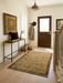 4' x 6' Rectangular Gold & Brown Textured Border Modern Area Rug placed in an elegant entryway hallway.