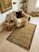 4' x 6' Rectangular Gold & Brown Textured Border Modern Area Rug styled in a cozy reading nook.