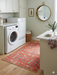 4' x 6' Rectangular Red & Blue Tree of Life Traditional Washable Area Rug placed in a bright laundry room on light wood floors.
