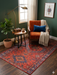 4' x 6' Rectangular Rust Red & Blue Tribal Geometric Medallion Traditional Area Rug styled in a reading nook with an accent chair and side table.