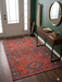 4' x 6' Rectangular Rust Red & Blue Tribal Geometric Medallion Traditional Area Rug styled in an entryway with a console table and wall mirror.