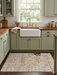 4' x 6' rectangular ivory multicolor distressed floral medallion traditional area rug placed in a cozy kitchen with green cabinetry and a farmhouse sink.