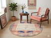 5' Round Peach & Blue Animal Motif Traditional Area Rug styled in a cozy reading nook with an accent chair and side table.