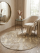 5' round beige & ivory marble abstract modern area rug styled in a cozy reading nook with a curved accent chair and soft neutral décor.