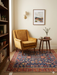 5' x 5' square navy blue & red floral medallion traditional area rug styled in a reading nook with a mid-century chair, side table, and neutral wall art.