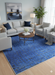 5' x 7' Rectangle Blue & Charcoal Abstract Modern Area Rug styled in a contemporary living room.
