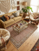 5' x 7' Rectangular Beige & Brown Floral Traditional Washable Area Rug styled in a cozy bohemian living room under a glass coffee table.