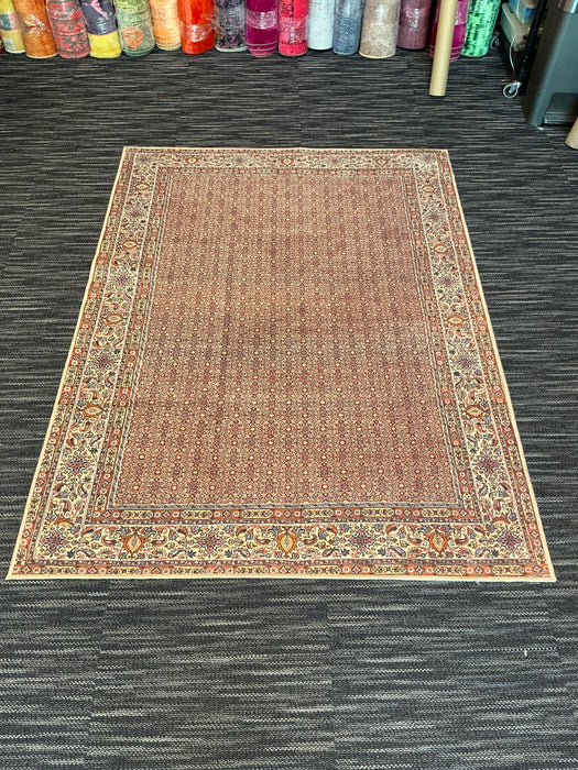 5' x 7' Rectangular Brown & Beige Floral Traditional Washable Area Rug displayed in a showroom on dark carpet.