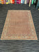 5' x 7' Rectangular Brown & Beige Floral Traditional Washable Area Rug displayed in a showroom on dark carpet.