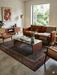 5' x 7' Rectangular Charcoal & Red Minimalist Tribal Border Modern Area Rug styled in a living room with a leather sofa, accent chairs, and natural light.