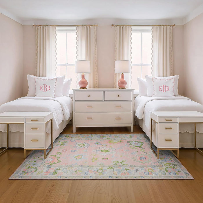 5' x 7' Rectangular Pink Multicolor Floral Traditional Washable Area Rug placed in a charming girls’ bedroom between two twin beds with pink monogram pillows and white furniture.