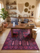 5' x 7' Rectangular Purple & Pink Tribal Southwestern Washable Area Rug placed in a creative home office beneath a wooden desk.