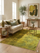 5' x 7' rectangular yellow & green distressed abstract modern area rug placed in a bright living room with neutral furniture and natural wood accents.