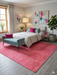 5' x 8' Rectangle Pink Distressed Modern Washable Area Rug styled in a bright bedroom with teal bench seating and colorful abstract wall art.